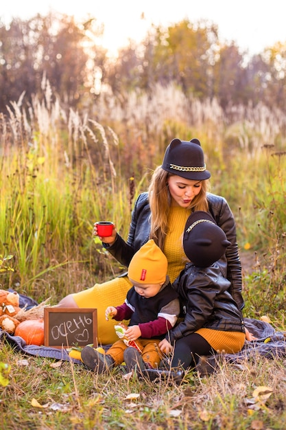 Hermosa familia con un perro golden retriever en un paseo en la naturaleza soleada de otoño