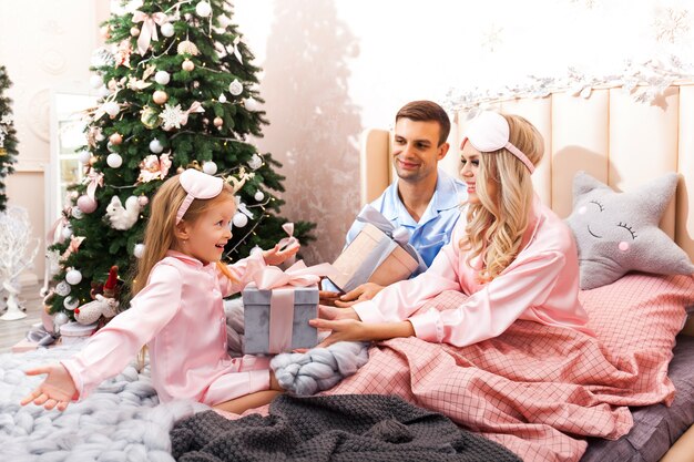 Hermosa familia en pijama celebrando la Navidad