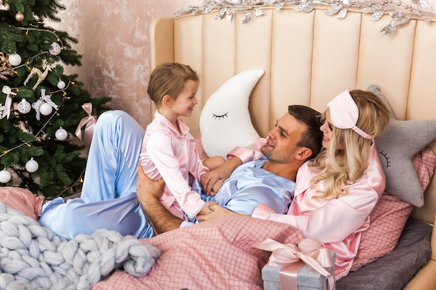 Hermosa familia en pijama celebrando la Navidad