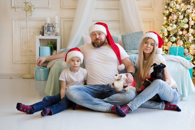 Hermosa familia sentada cerca del árbol de Navidad