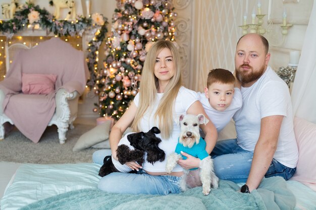 Hermosa familia sentada cerca del árbol de Navidad