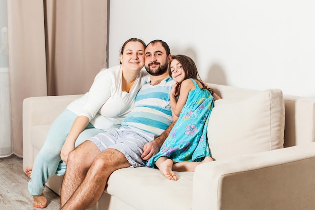 Hermosa familia sentada en un sofá en la sala de estar.