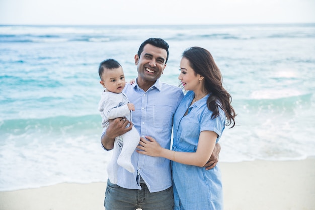 Hermosa familia sonriendo cuando vacaciones en la playa