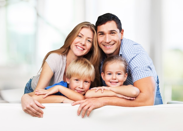 Hermosa familia sonriente en la habitación en el sofá