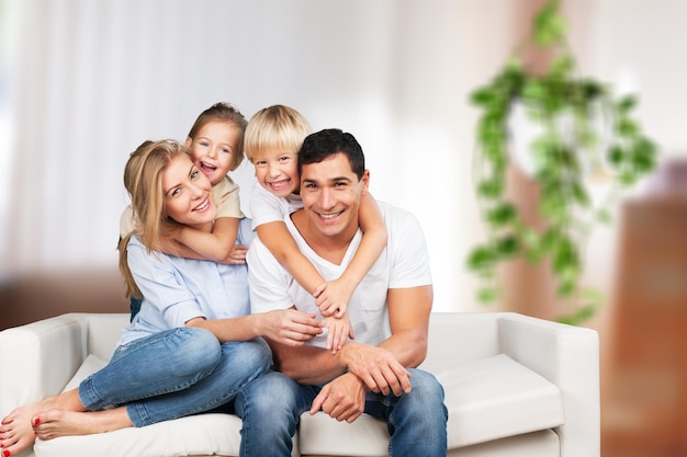 Hermosa familia sonriente en la habitación en el sofá