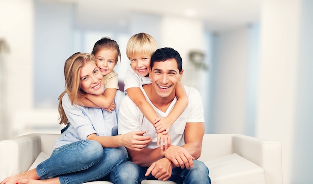 Hermosa familia sonriente sentada en el sofá en casa