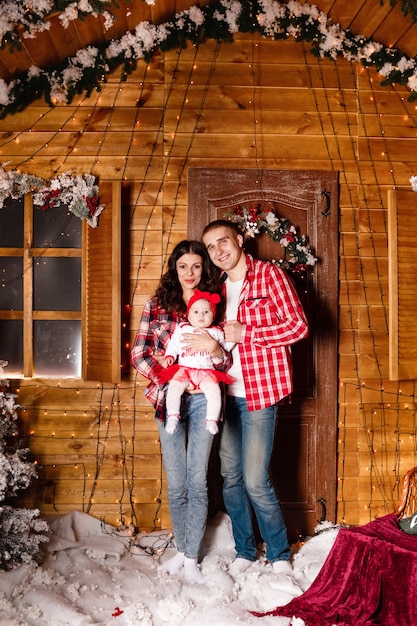 Hermosa familia con su bebé frente a una casa