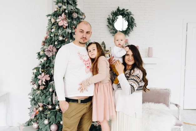 Hermosa feliz familia caucásica de cuatro cerca del árbol de Navidad