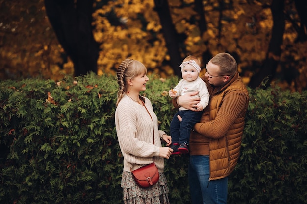Hermosa y feliz familia con un niño pequeño en el parque