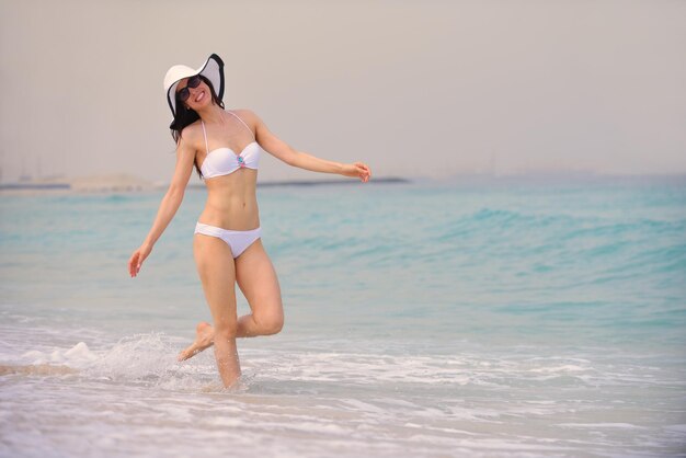 hermosa y feliz mujer niña en la playa diviértete y relájate en las vacaciones de verano sobre el hermoso mar tropical