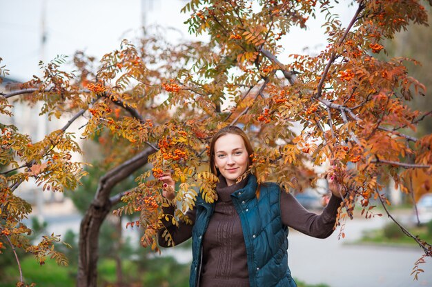 Hermosa y feliz mujer sonríe y camina en otoño Parque.