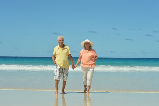 Hermosa feliz pareja de ancianos en la playa en el resort tropical