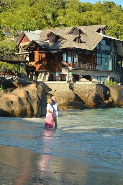 Hermosa feliz pareja de ancianos en la playa en el resort tropical