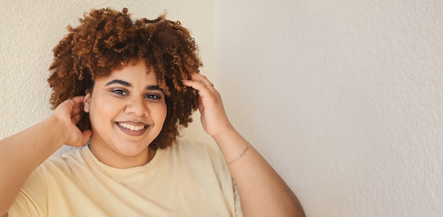 Foto hermosa feliz sonriente curvy plus size afro mujer negra africana cabello con maquillaje posando en beige