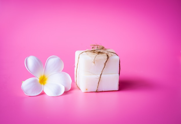 Hermosa flor de plumeria blanca y jabon de leche en rosa