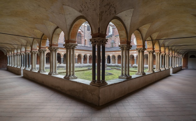 Hermosa foto de arcadas del claustro y un patio.