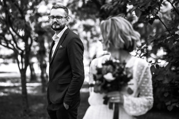 Hermosa foto en blanco y negro de la novia y el novio Feliz pareja posando y sonriendo en vestido de novia