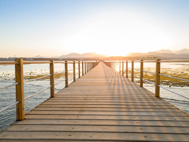 Hermosa foto de largo muelle de madera o puente en el océano