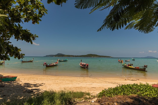 Hermosa foto de un montón de barcos en un mar bajo el cielo nublado en Rawai Beach Phuket