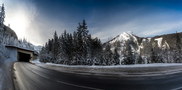 Hermosa foto panorámica de la carretera en montañas nevadas con giro largo