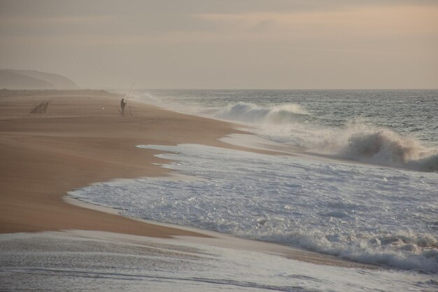 Hermosa foto de un pescador y grandes olas durante el día.