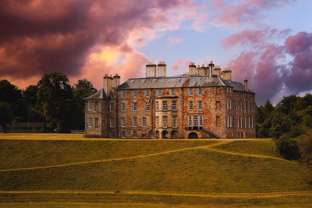 Una hermosa fotografía del histórico Palacio de Dalkeith bajo un cielo nublado al anochecer en Escocia