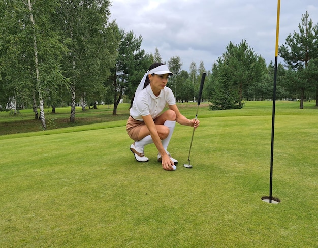 Hermosa golfista pone con éxito la pelota en el campo