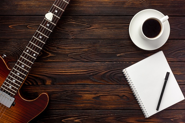 Hermosa guitarra eléctrica con auriculares y escritorio de café