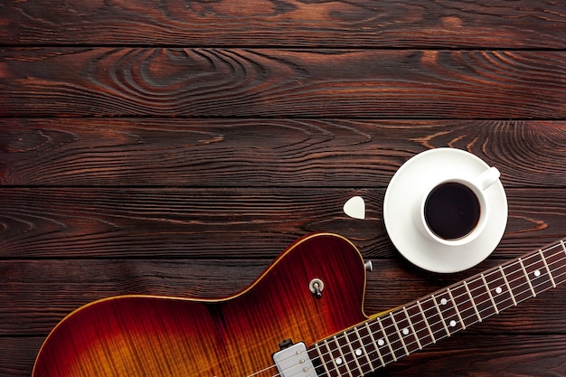 Hermosa guitarra eléctrica con auriculares y escritorio de café