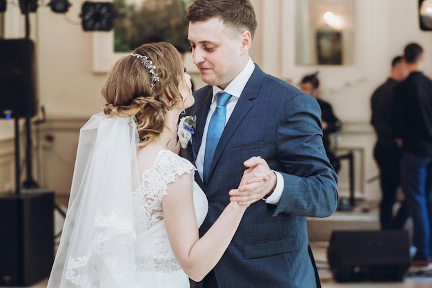 Hermosa hermosa novia y el novio realizando el primer baile feliz pareja de novios bailando en el restaurante en la recepción de la boda momentos de matrimonio feliz concepto de fuga