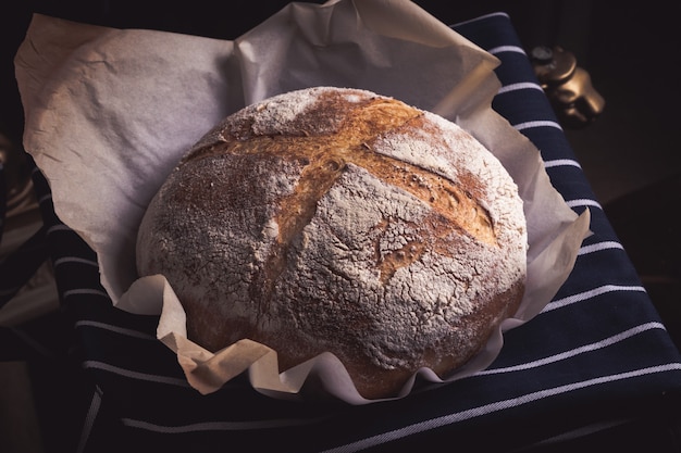 Hermosa imagen de pan de fermentación italiano rústico horneado en la mesa con un paño azul marino