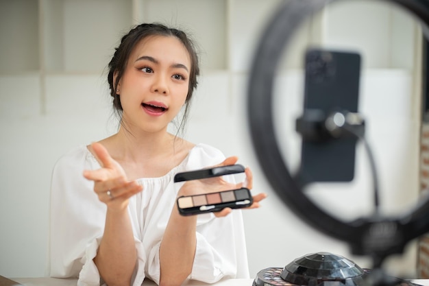 Una hermosa influencer de belleza asiática está haciendo un video de contenido de belleza en su estudio de casa