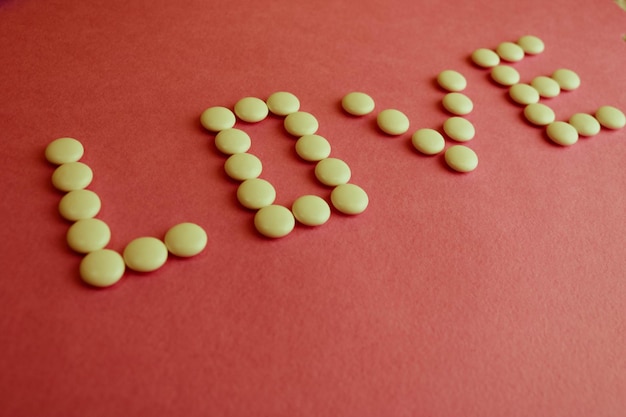 Hermosa inscripción amor hecha de pastillas médicas suaves redondas blancas vitaminas antibióticos