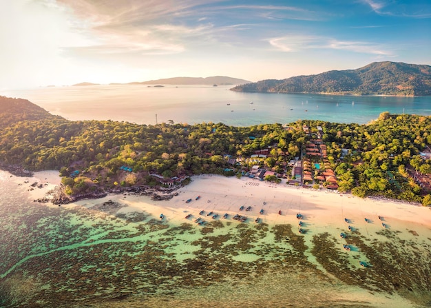 Hermosa isla Koh Lipe con barco de pesca tropical y resort en la playa en vacaciones de verano al atardecer