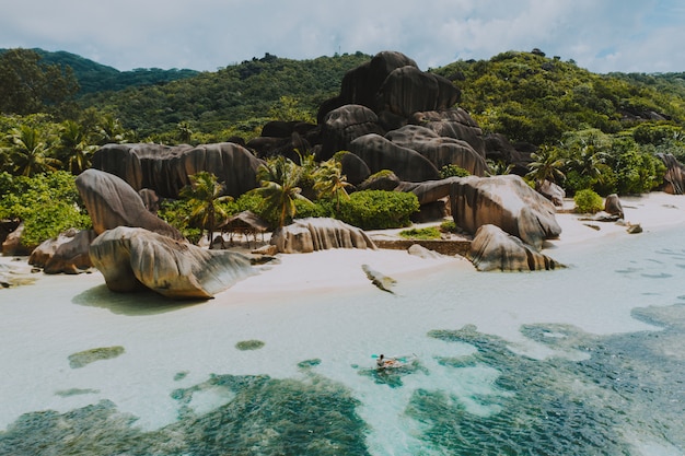 Hermosa isla en las seychelles. La digue, playa de anse d'argent con vista aérea. Hombre en kayak con kayak transparente en la mañana