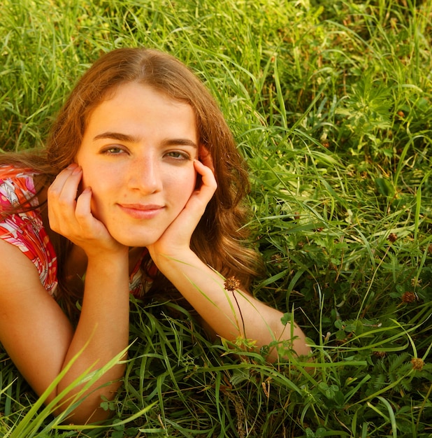 Hermosa joven se acuesta sobre un césped