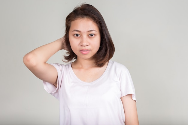 Hermosa joven adolescente asiática con pelo corto en blanco