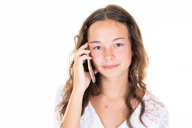 Hermosa joven adolescente hablando por teléfono en el estudio en fondo blanco.