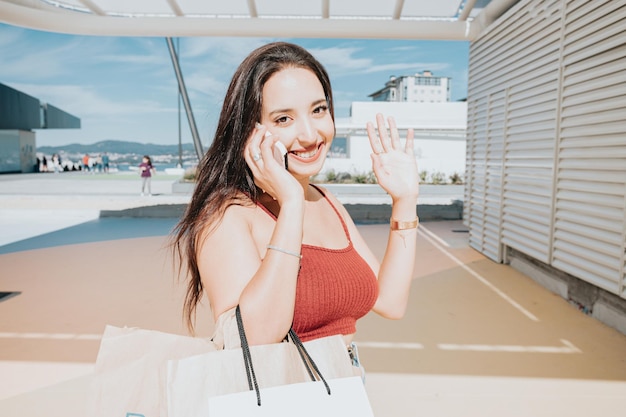 Hermosa joven africana con bolsas de compras en el centro comercial de la calle de la ciudad. Copie el espacio, concepto de regalos de compras de Navidad año nuevo, día de compras de ropa nueva. Estilo moderno y conceptos de mujer joven