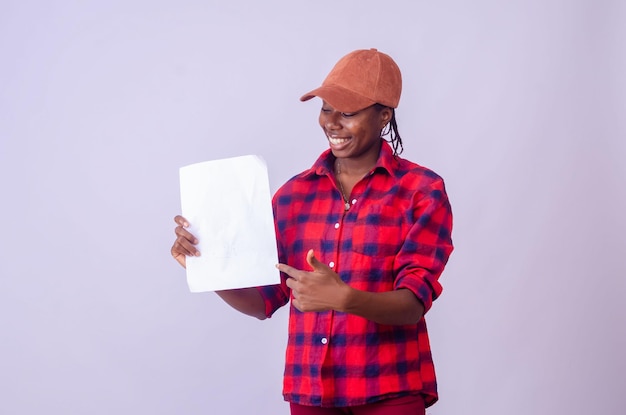 Hermosa joven africana sonriendo mientras sostiene un bloc en blanco