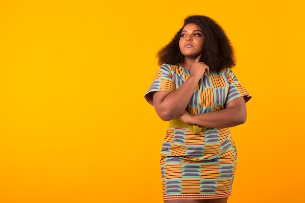 Hermosa joven afroamericana con un peinado afro en amarillo