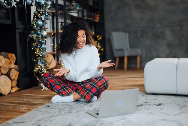 Hermosa joven afroamericana en el suelo cara feliz sonriendo y mirando a la cámara Persona positiva