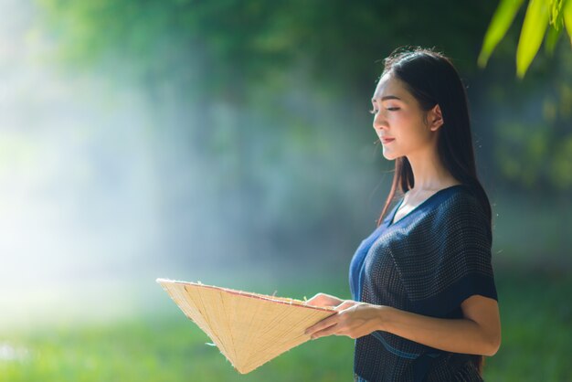 Hermosa joven agricultor en Tailandia, mujer sonriendo con sonrisa perfecta y feliz en el bosque.