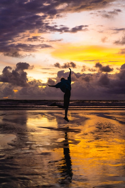 Hermosa joven al atardecer en el océano, Bali, Indonesia.