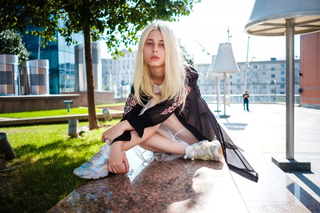 Hermosa joven albina posando cerca de un centro de negocios en Moscú.