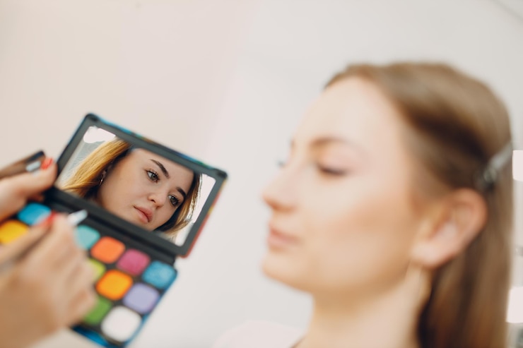 Foto hermosa joven aplicando pincel de rostro de belleza de maquillaje