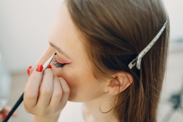 Hermosa joven aplicando pincel de rostro de belleza de maquillaje