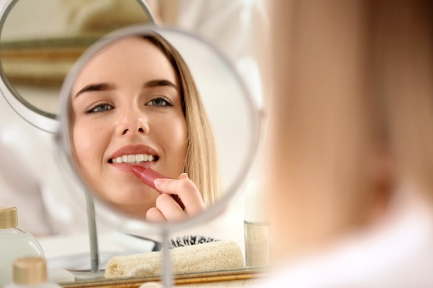 Hermosa joven aplicar maquillaje en la mañana