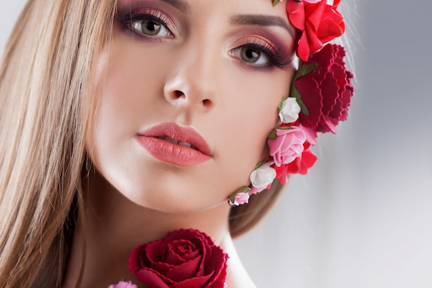 Hermosa joven con apliques de flores en la cara.