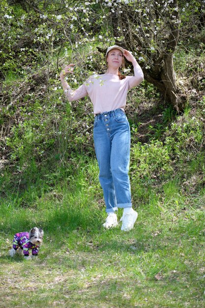 Hermosa joven con un árbol en flor en el jardín.